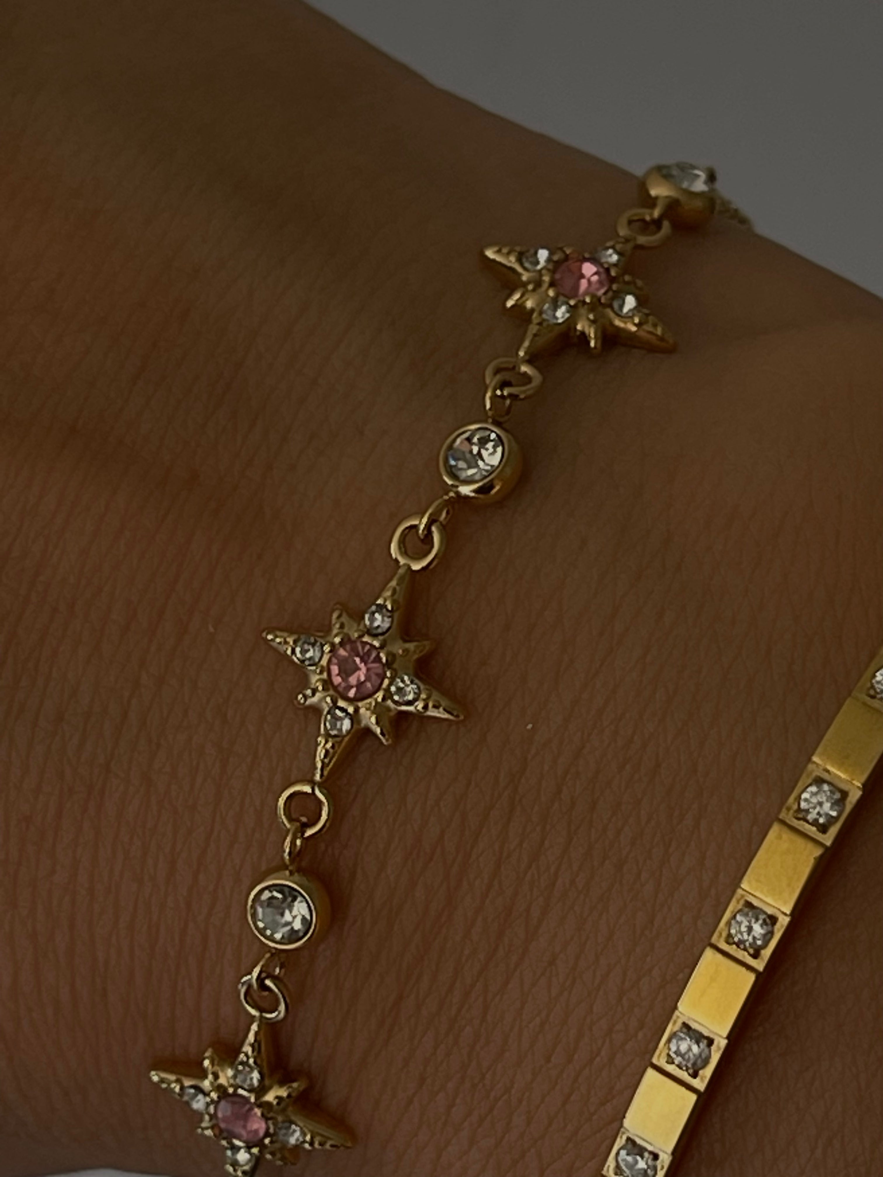Bracelet Polaris porté au poignet, étoiles pavées de cristaux avec éclat rose, acier plaqué or 18K