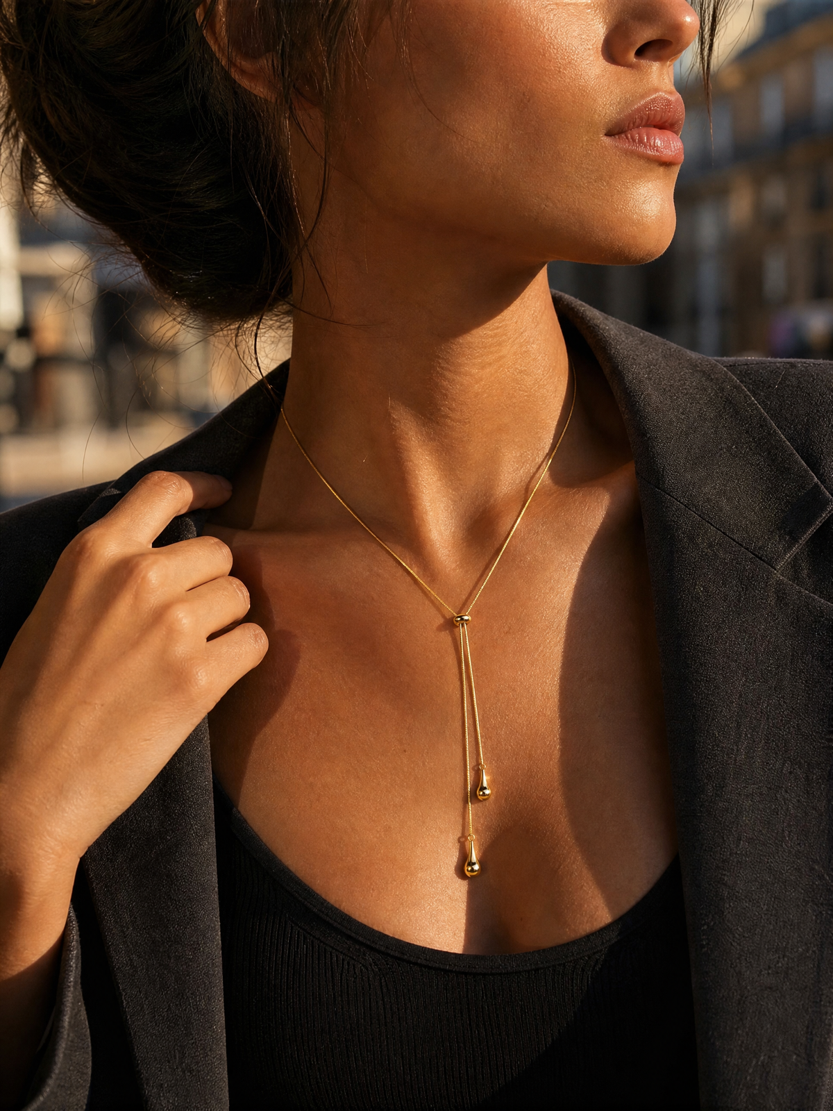 Collier Thaïs doré porté avec un blazer anthracite, chaîne serpent et gouttes pendantes