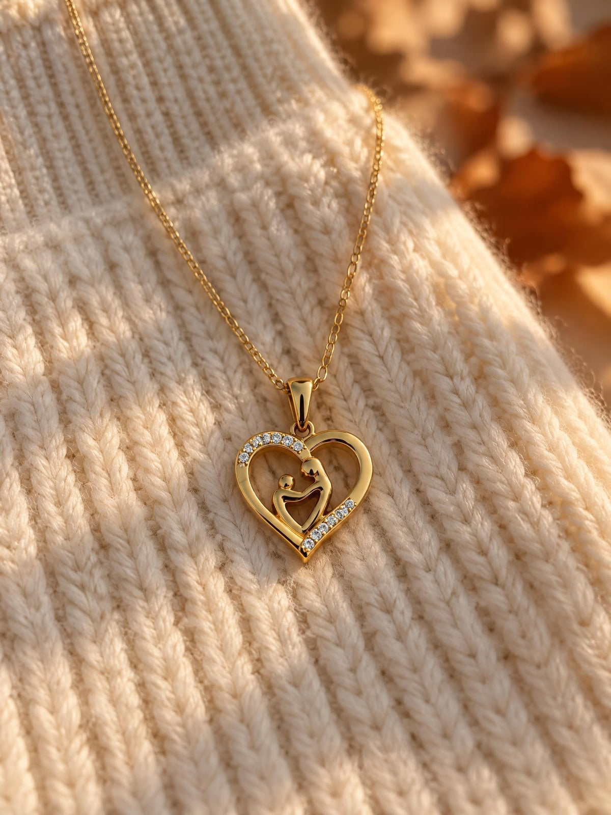 Collier Maélie posé sur un pull en maille crème, pendentif cœur doré pavé de zircons, ambiance automne