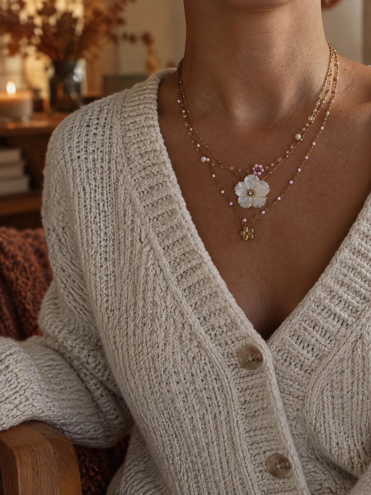 Combo Douceur & Aurora porté dans un intérieur d'automne, bougie et fleurs séchées en arrière-plan