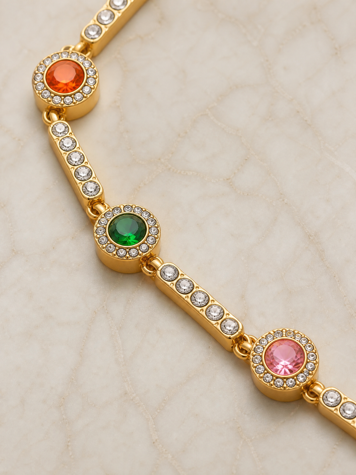 Détail macro du bracelet Garance – pierres orange, verte et rose serties clos entre des barrettes pavées de zircons