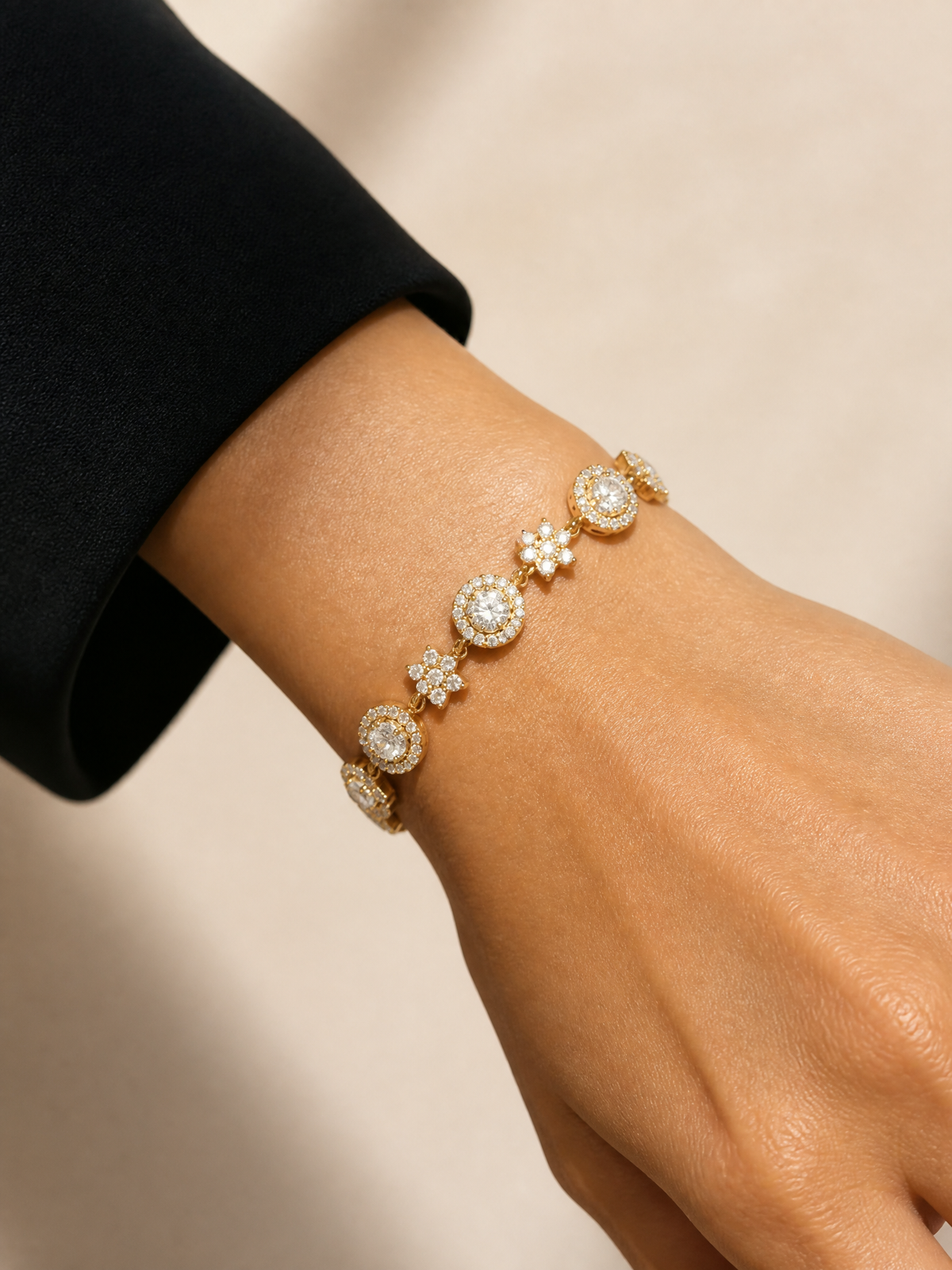 Bracelet Stella porté au poignet – solitaires ronds cerclés de zircons alternés avec de petites fleurs pavées, acier inoxydable doré