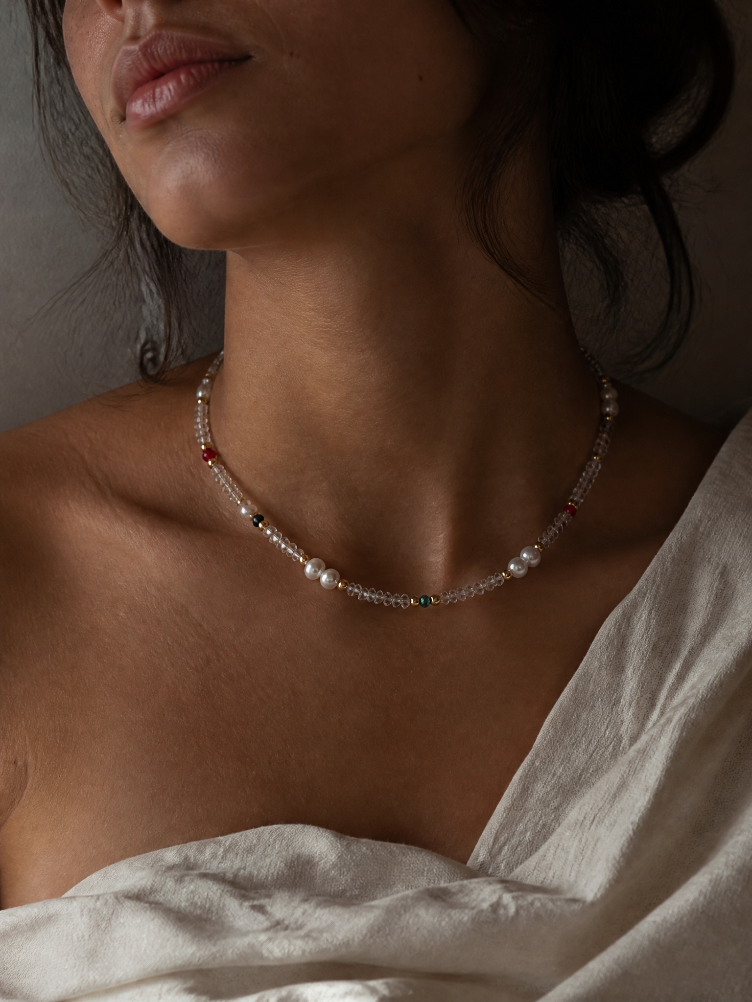 Collier Harmonia porté à la base du cou : rang de cristal facetté, perles d'eau douce et billes dorées