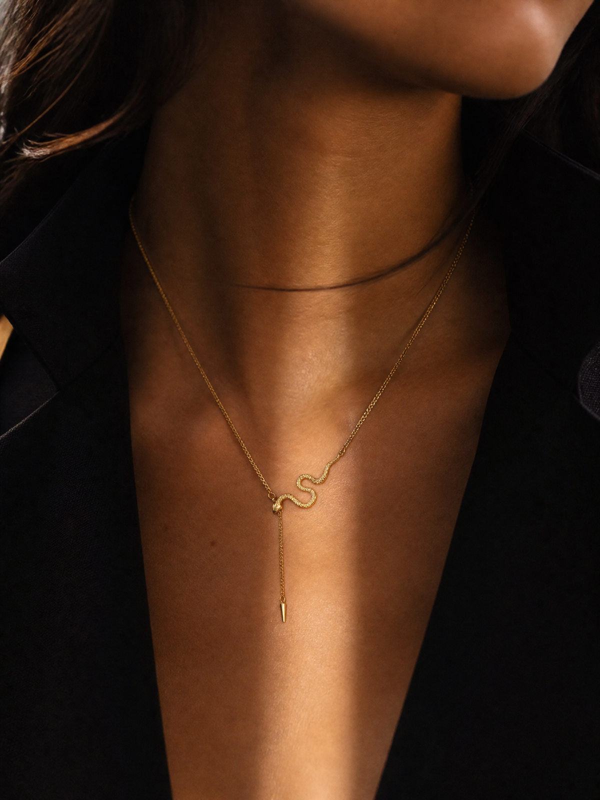 Collier Serpentina porté : serpent doré sur chaîne fine, pointe effilée suspendue