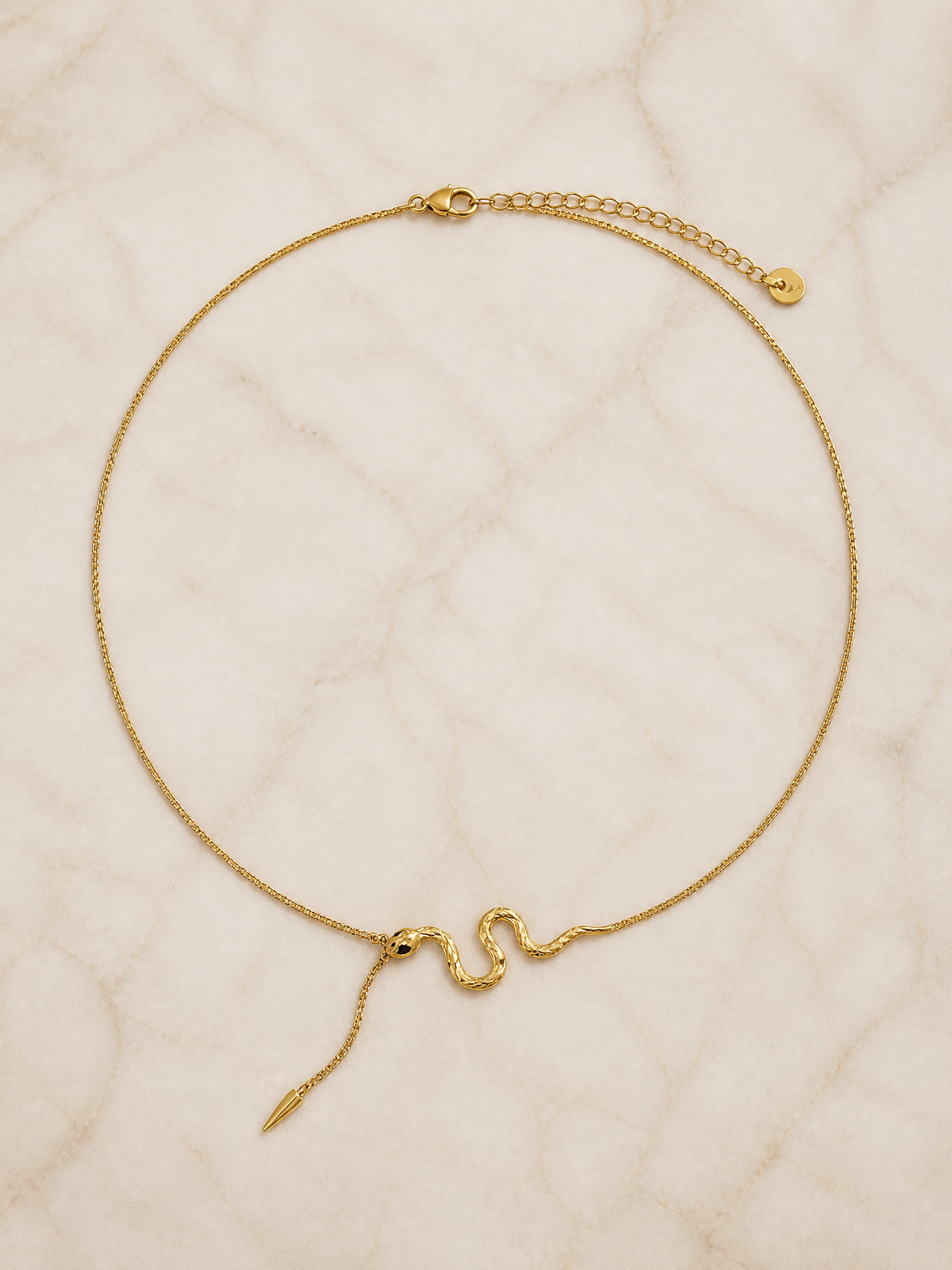 Collier Serpentina en macro : corps du serpent ciselé et éclats verts sur la tête